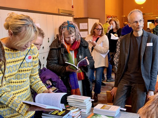Mathias Tistelgren, filosofisk praktiker, vid ett bokbord tillsammans med andra filosofiintresserade. Foto: Ann Lagerström